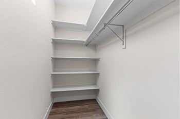 A white wall with a set of shelves and a skylight.